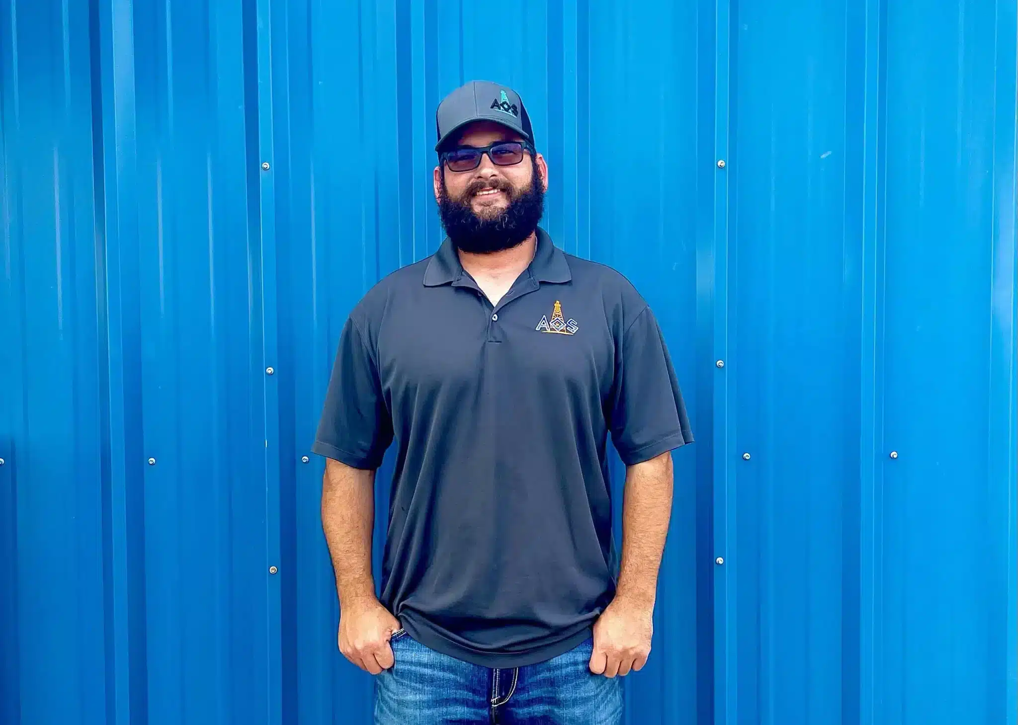 AOS Worker in front of a blue building